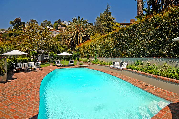 Hollywood Hills swimming pool with hand-laid brick herringbone surround, hand-carved scalloped stucco wall, Hollywood Hills view. ESRL Development.
